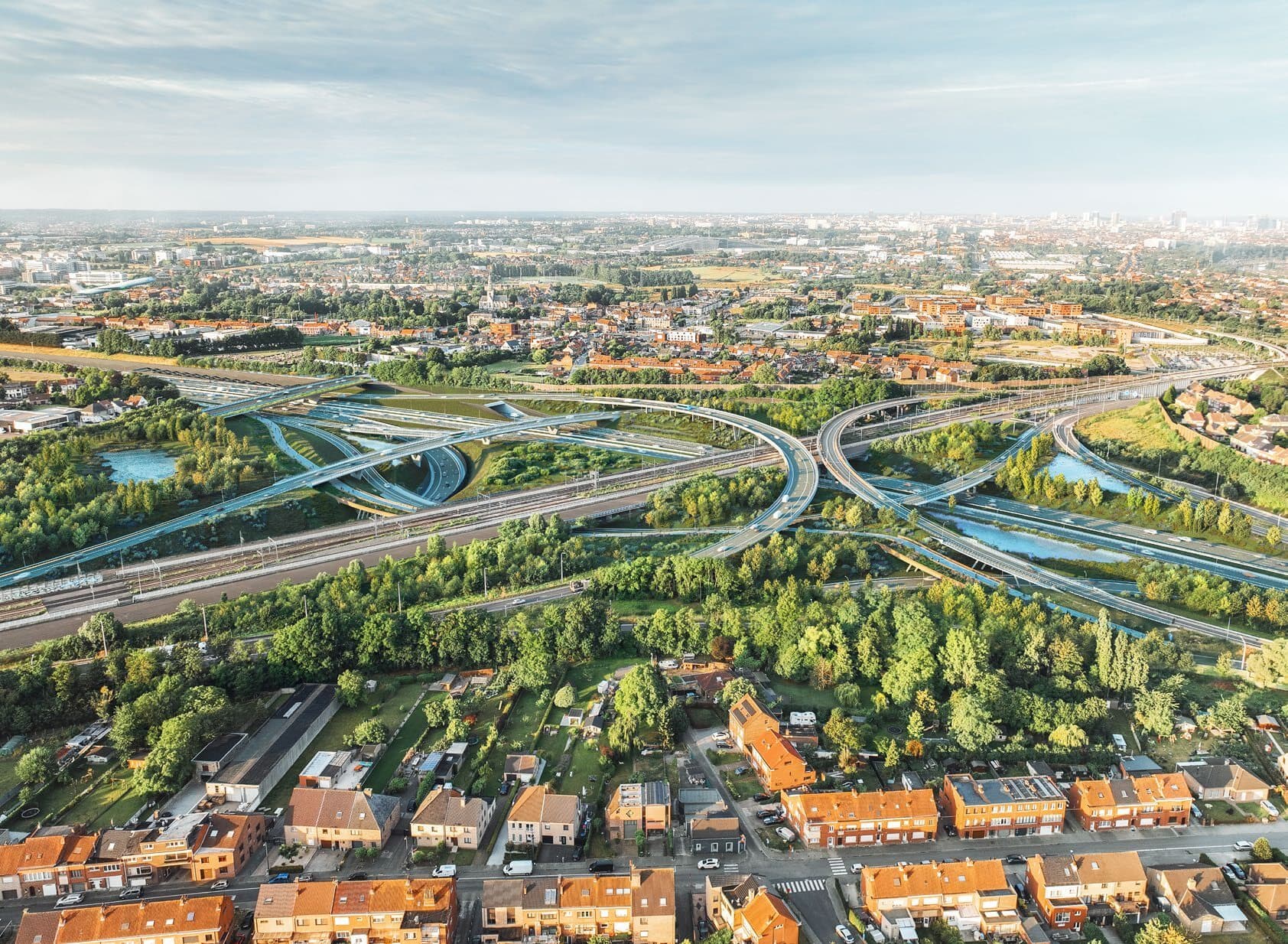 Luchtrender van het herontworpen verkeersknooppunt in de Ring van Brussel, compact ingepast tussen woonwijken en groen